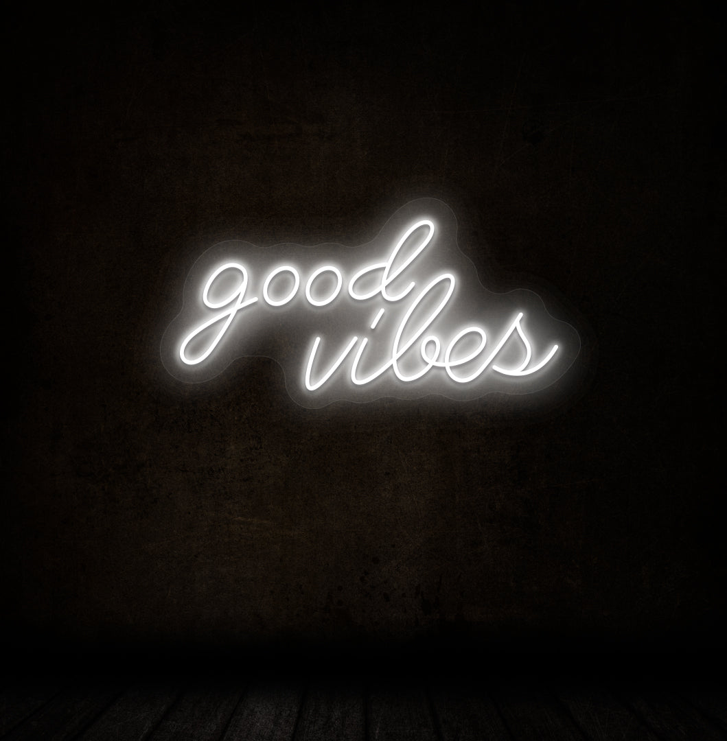 A stylish white LED "good vibes" neon sign mounted on a dark wall. Perfect for bedrooms, gaming, streaming setups, and cafés.
