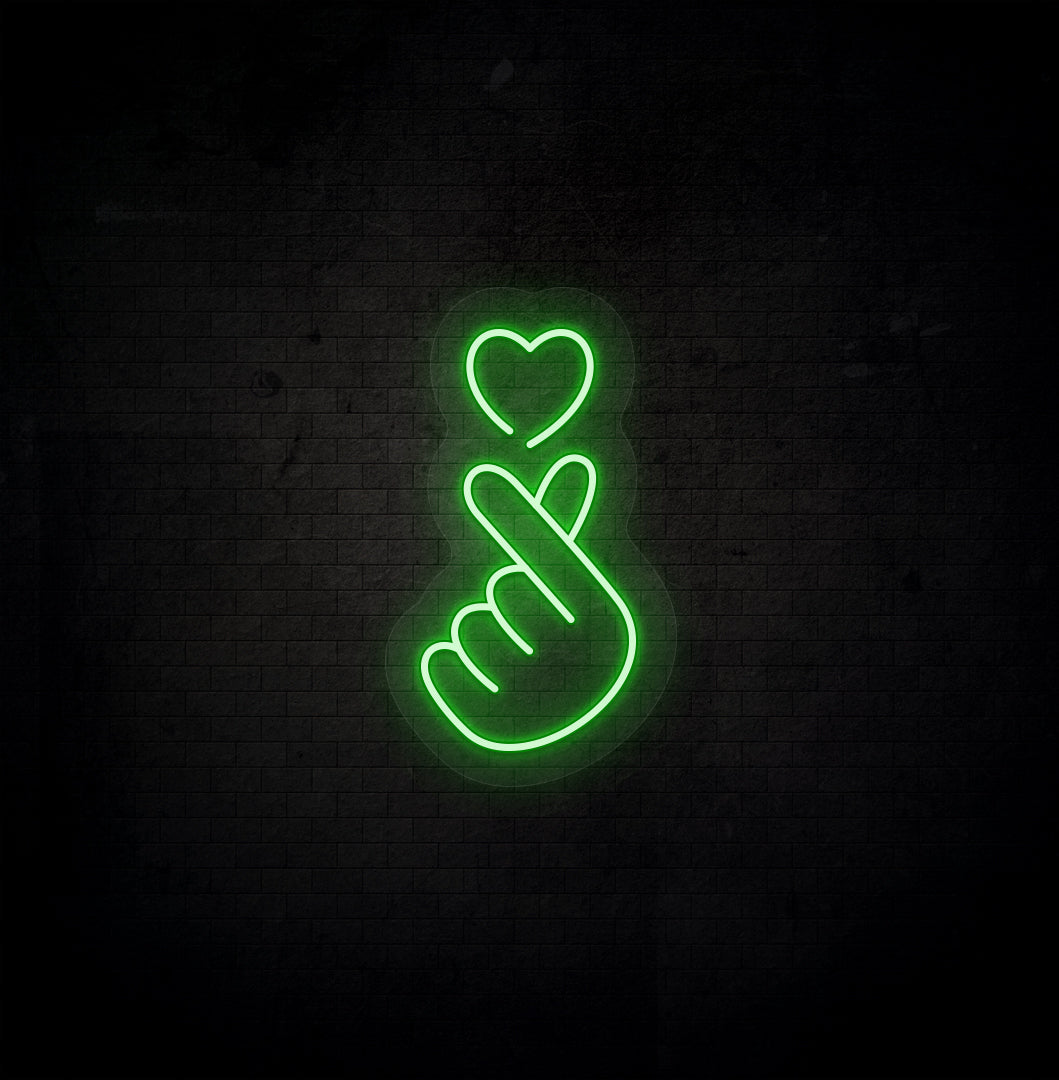 A stylish green LED hand heart neon sign glowing on a dark background wall.