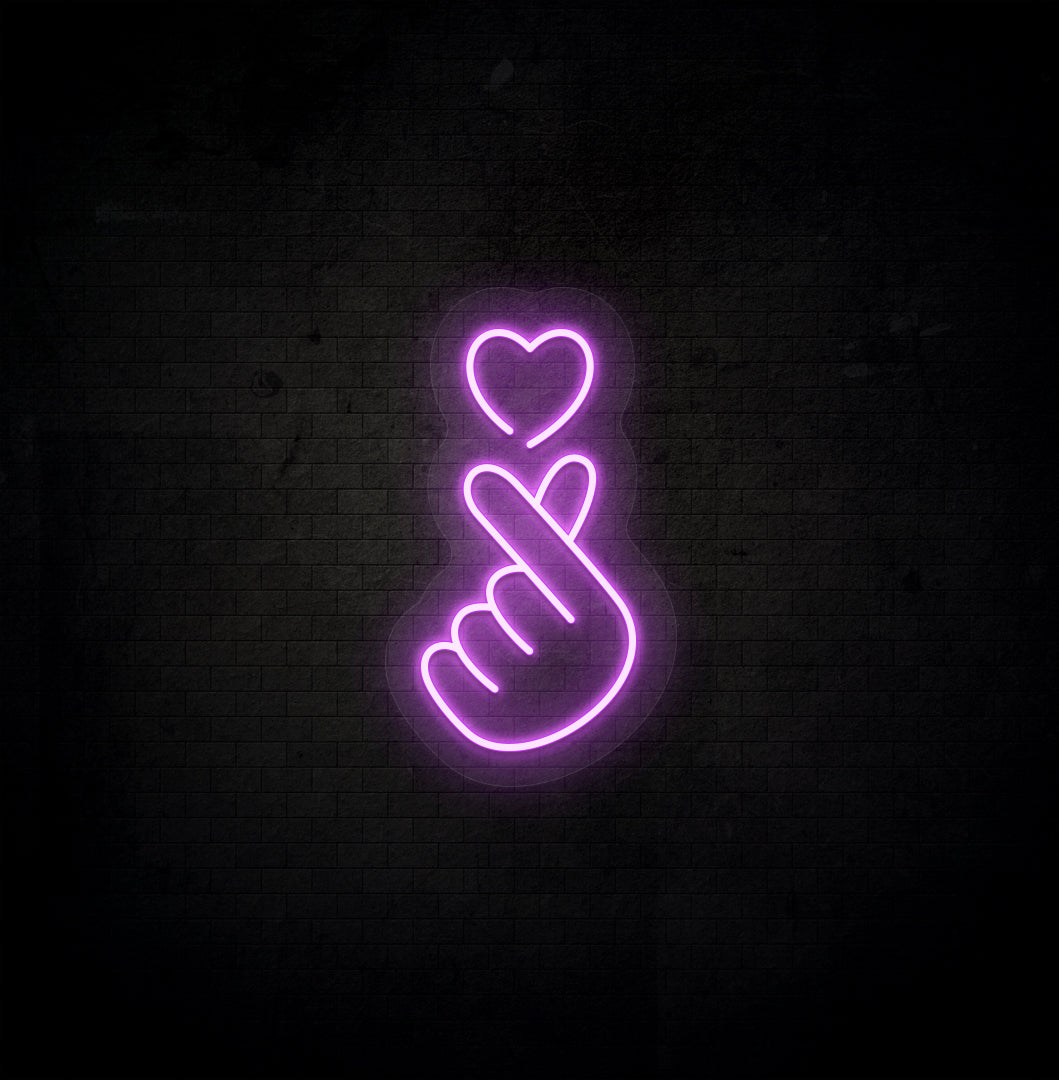 A stylish purple LED hand heart neon sign glowing on a dark background wall.