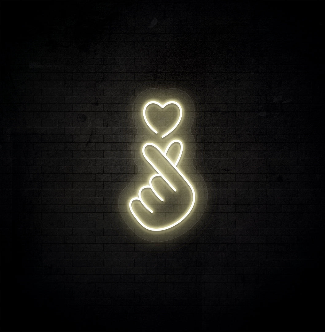A stylish warm white LED hand heart neon sign glowing on a dark background wall.