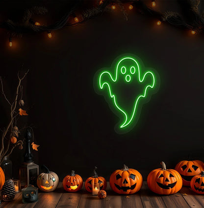 Modern Halloween wall with haunted ghost neon sign glowing green above pumpkins.