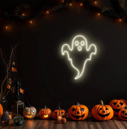 Modern Halloween wall with haunted ghost neon sign glowing warm white above pumpkins.