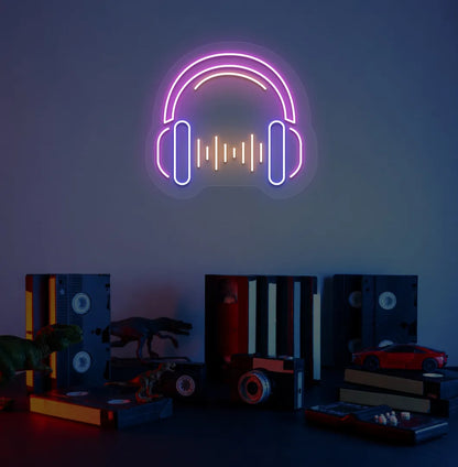 Image of a headphone neon sign in pink color mounted on room wall.