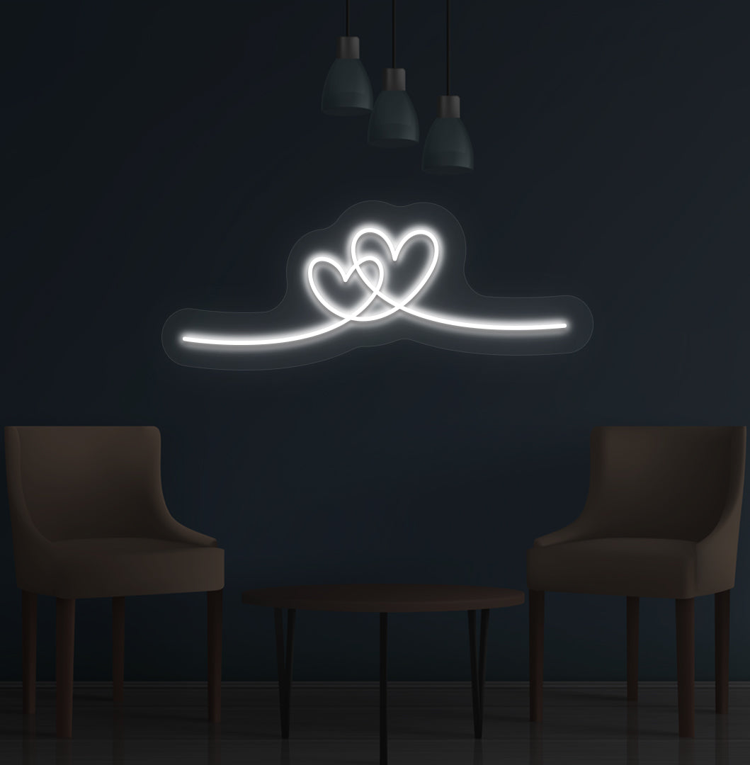 Image of a romantic heart LED neon sign glowing on a wall in white color.