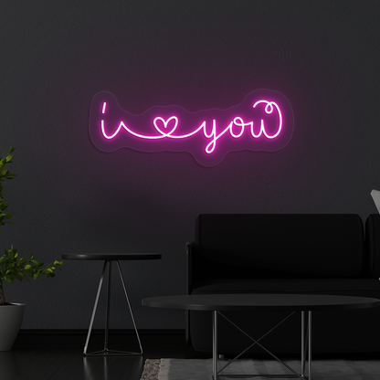 Image of a Romantic "I love you" neon sign glowing on a wall in pink color.