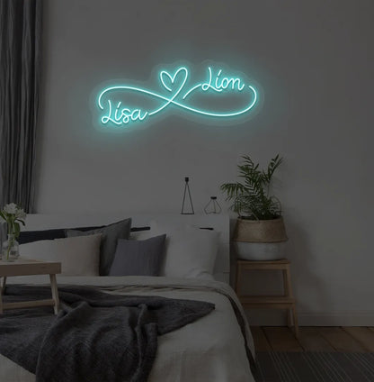 Custom Infinity Couple Name ice blue LED neon sign mounted on bedroom wall.