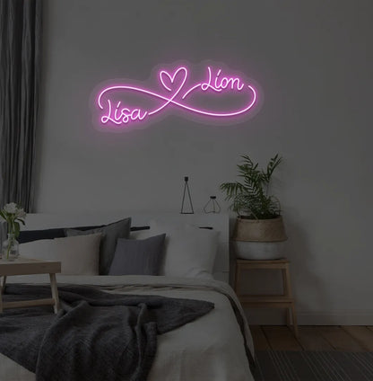 Personalized infinity couple name neon sign mounted on modern bedroom wall in purple color.