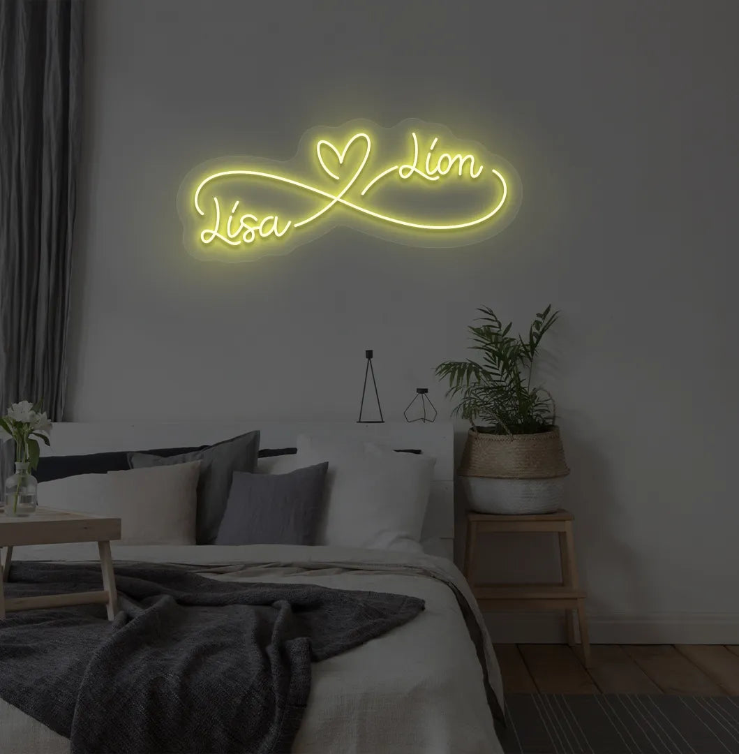 Personalized infinity couple name neon sign mounted on modern bedroom wall in yellow color.