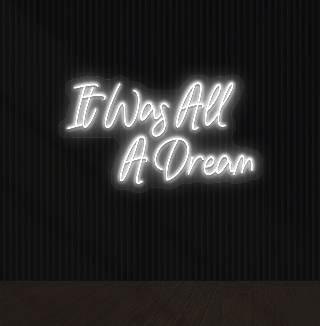 Image of an "it was all a dream" LED neon sign glowing on a dark wall in white color.