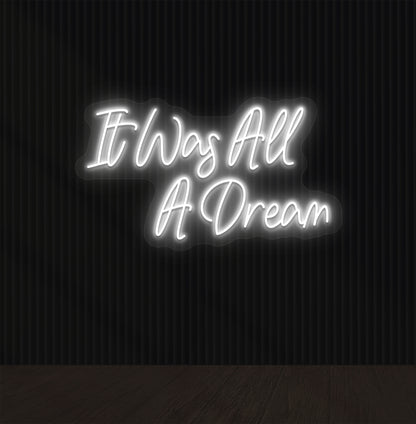 Image of an "it was all a dream" LED neon sign glowing on a dark wall in white color.