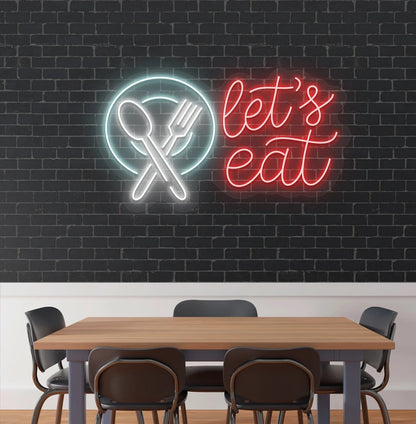 Image of a let’s eat neon sign with plate and cutlery icon glowing on cafe wall in red color.