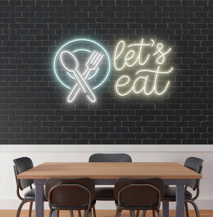 Let’s eat neon sign with a plate and crossed cutlery icon in warm white cafe interior.