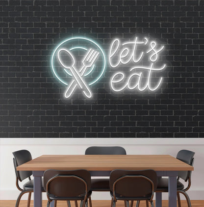 Image of a let’s eat neon sign with plate and cutlery icon glowing on cafe wall in white color.