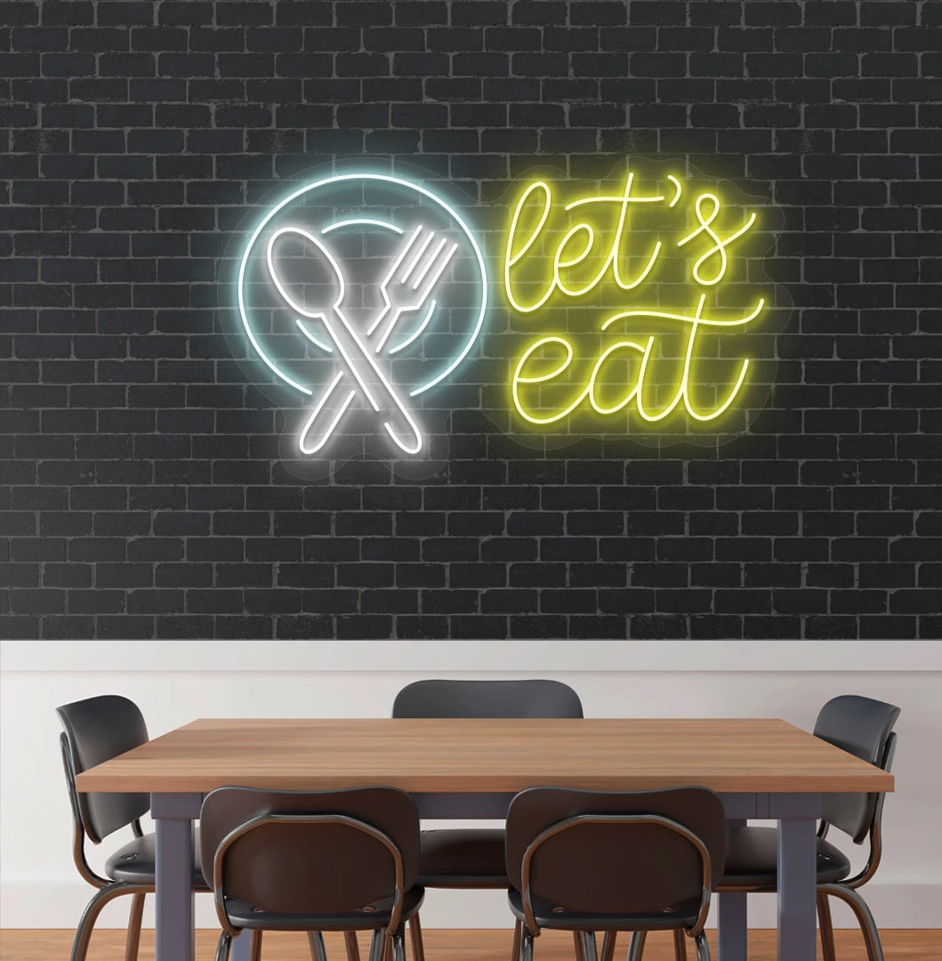 Let’s eat neon sign with a plate and crossed cutlery icon in yellow cafe interior.