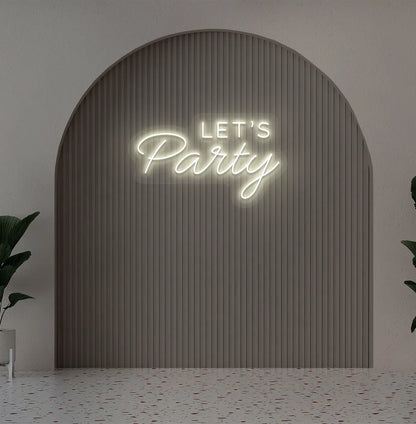 Image of a festive Let's Party warm white neon sign glowing on decorative wall.