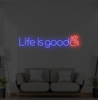Image of a positive "life is good" LED neon sign glowing blue on wall.