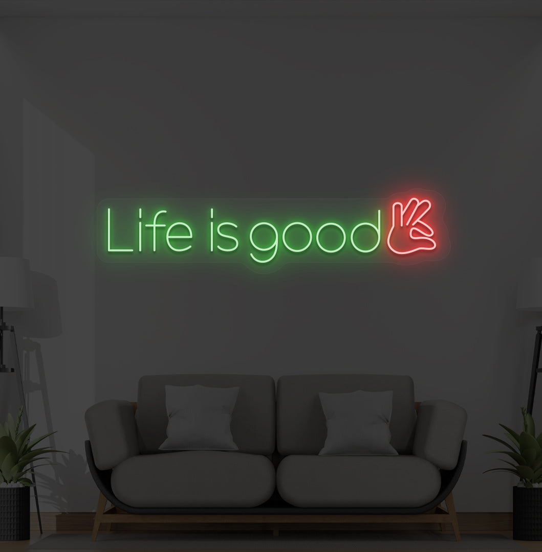 Aesthetic wall with "life is good" neon sign glowing green.
