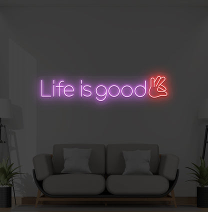 Aesthetic wall with "life is good" neon sign glowing purple.
