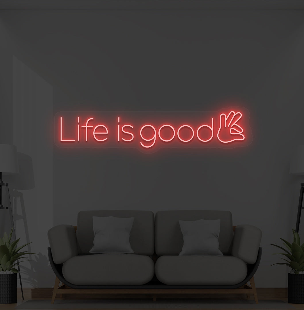 Image of a positive "life is good" LED neon sign glowing red on wall.