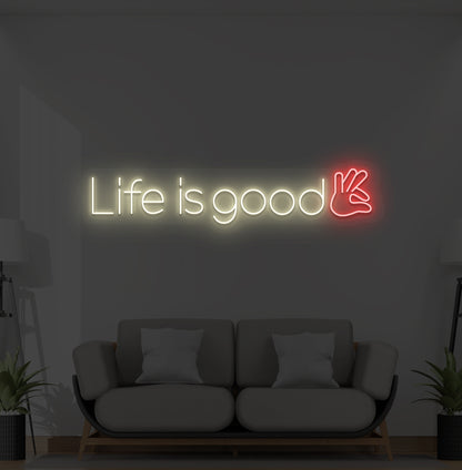 Aesthetic wall with "life is good" neon sign glowing warm white.