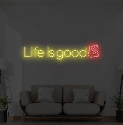 Aesthetic wall with "life is good" neon sign glowing yellow.