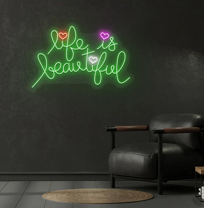 Trendy Life Is Beautiful neon sign mounted on aesthetic bedroom wall in green color.