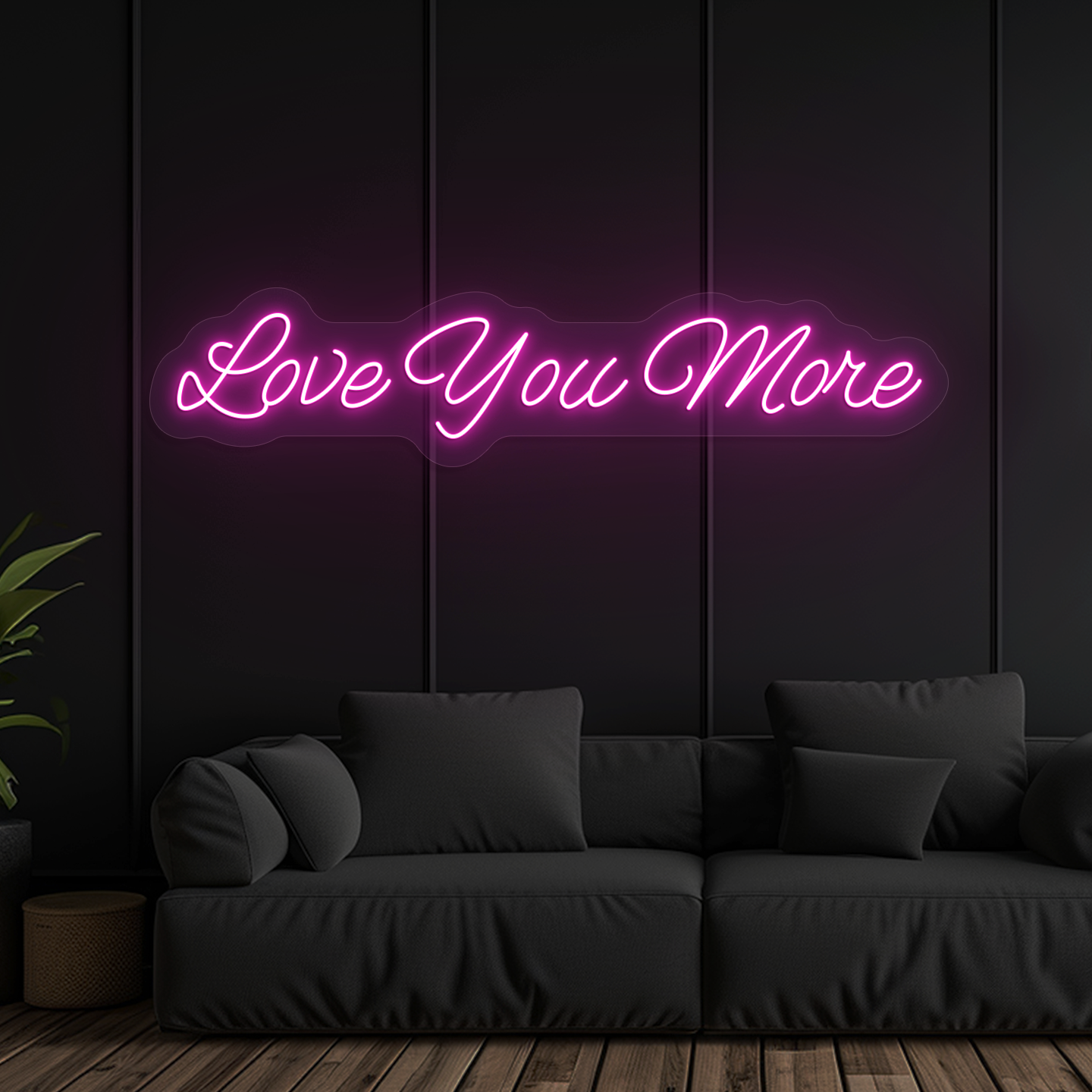 Image of a "love you more" LED neon sign glowing on wall in pink color.
