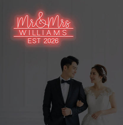 Personalized Mr and Mrs wedding neon sign glowing red on wedding backdrop.