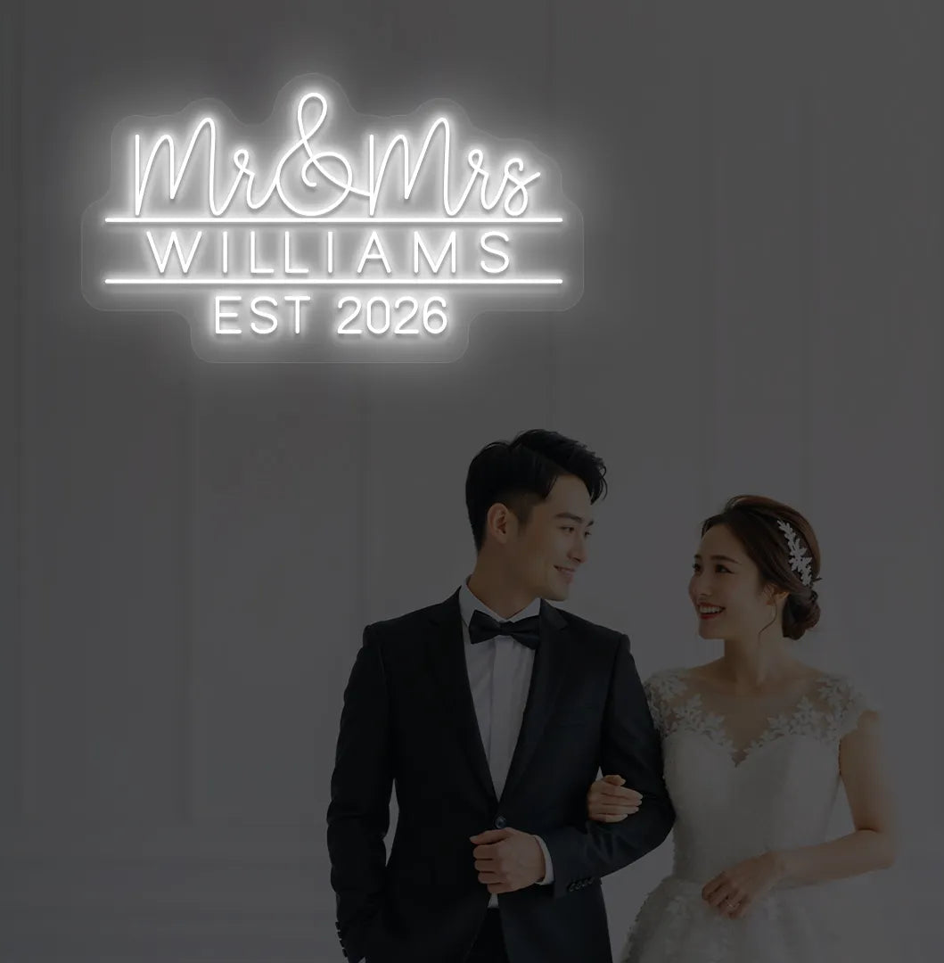 Personalized Mr and Mrs wedding neon sign glowing white on wedding backdrop.