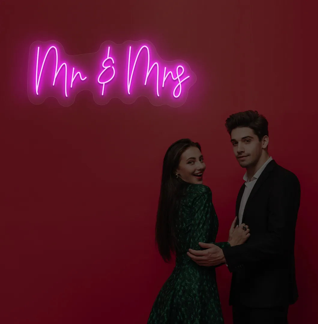 Image of a stylish Mr and Mrs wedding neon sign mounted on aesthetic wall in pink color.