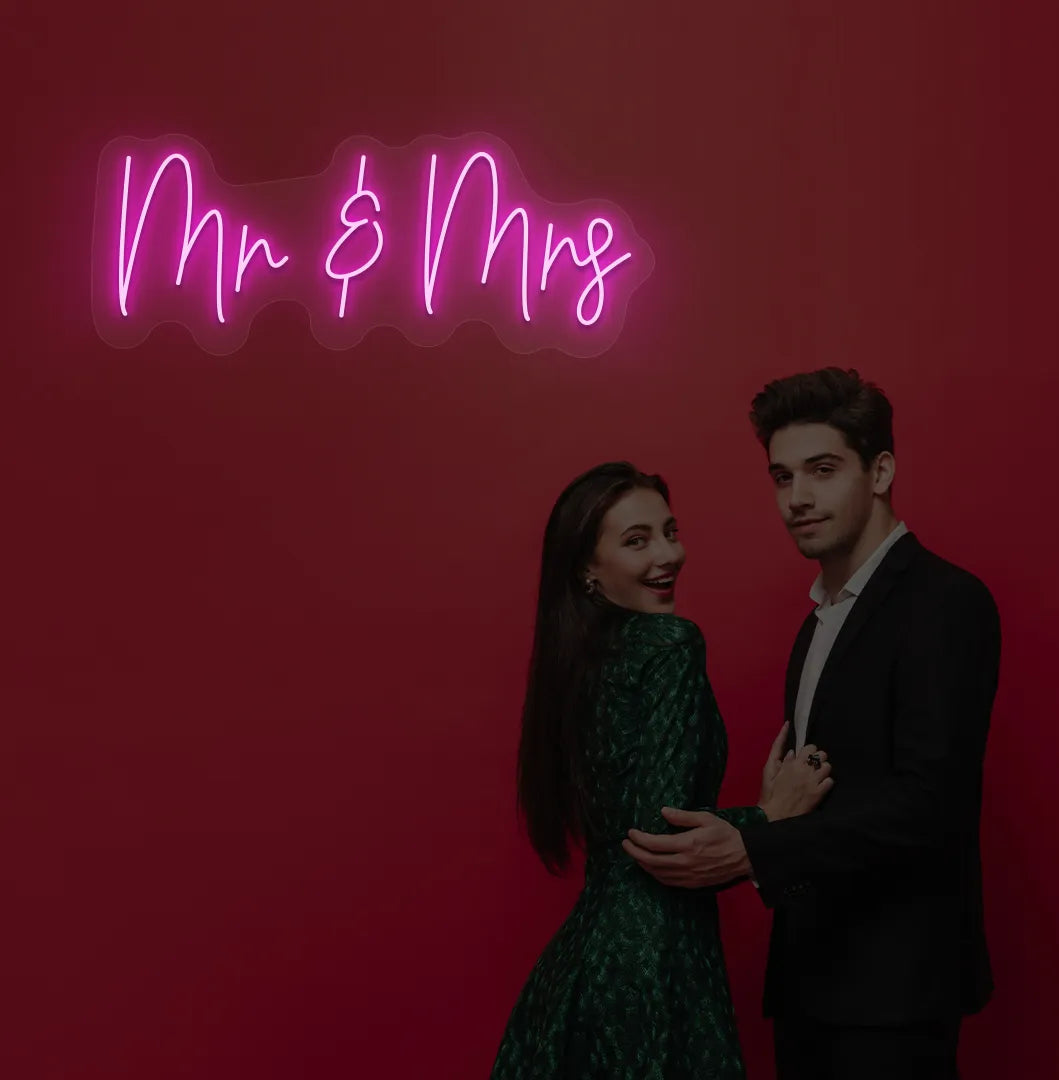 Elegant Mr and Mrs wedding neon sign glowing purple on wedding backdrop.
