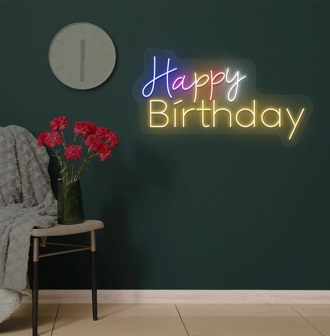 Trendy multicolor Happy Birthday neon sign mounted on party backdrop wall in orange color.