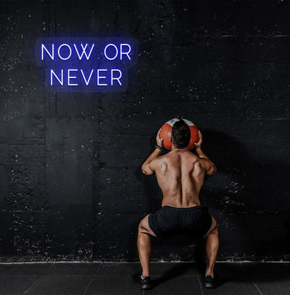 Image of a bright blue "now or never" neon sign for motivational gym decor.