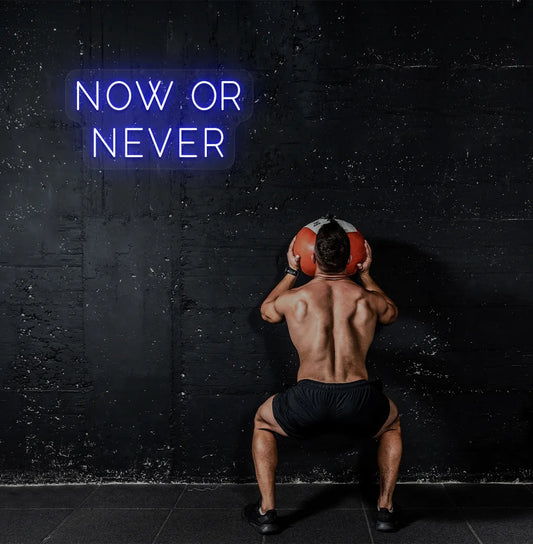 Image of a bright blue "now or never" neon sign for motivational gym decor.