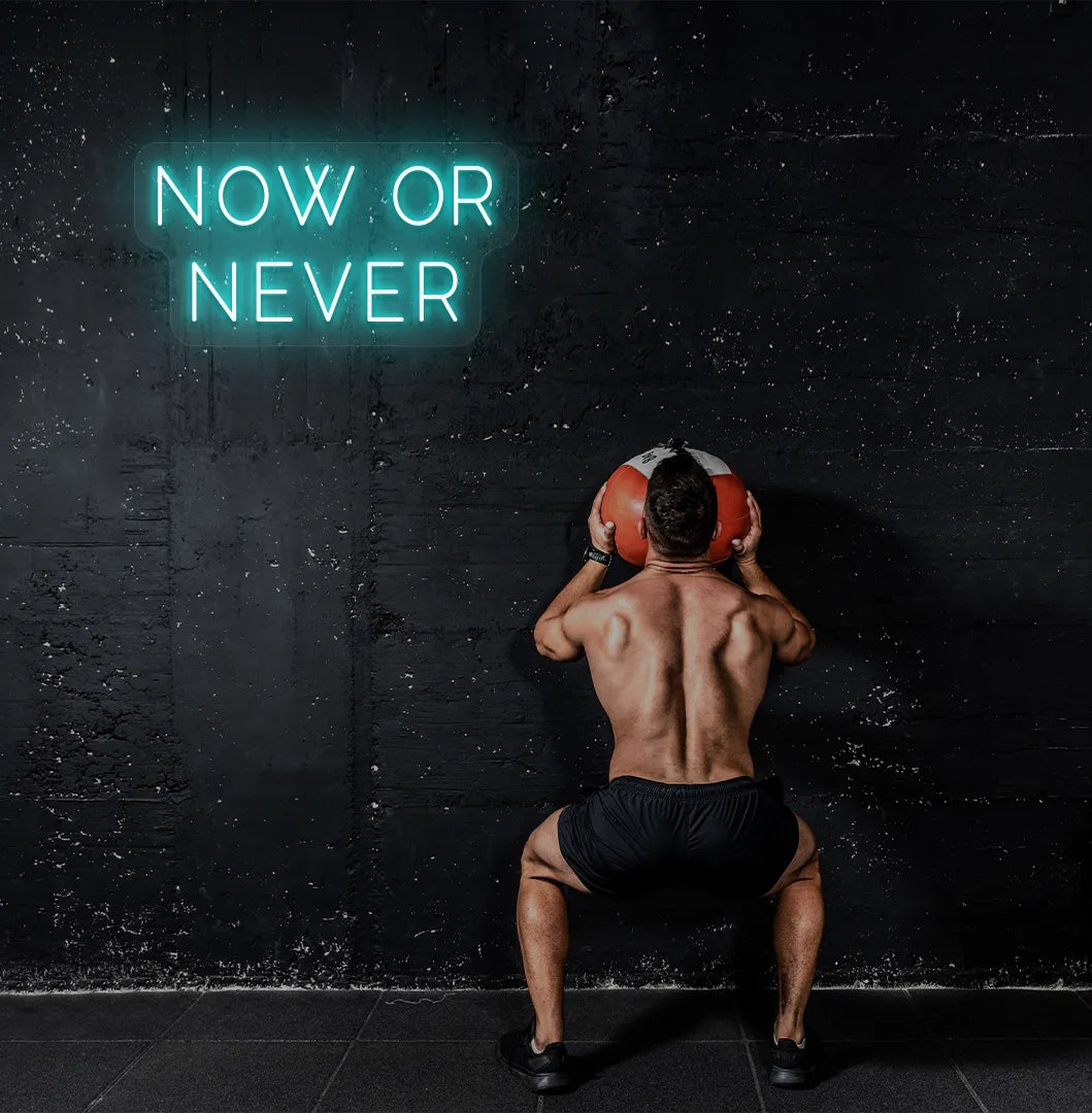 Image of a bright ice blue "now or never" neon sign for motivational gym decor.