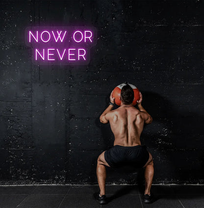 Image of a bright pink "now or never" neon sign for motivational gym decor.