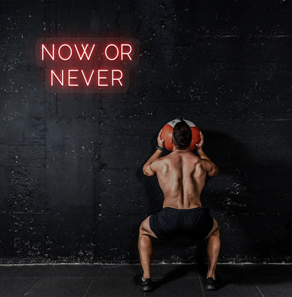 Image of a bright red "now or never" neon sign for motivational gym decor.