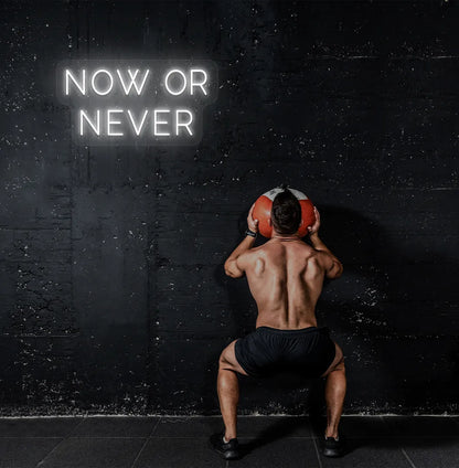 Image of a bright white "now or never" neon sign for motivational gym decor.
