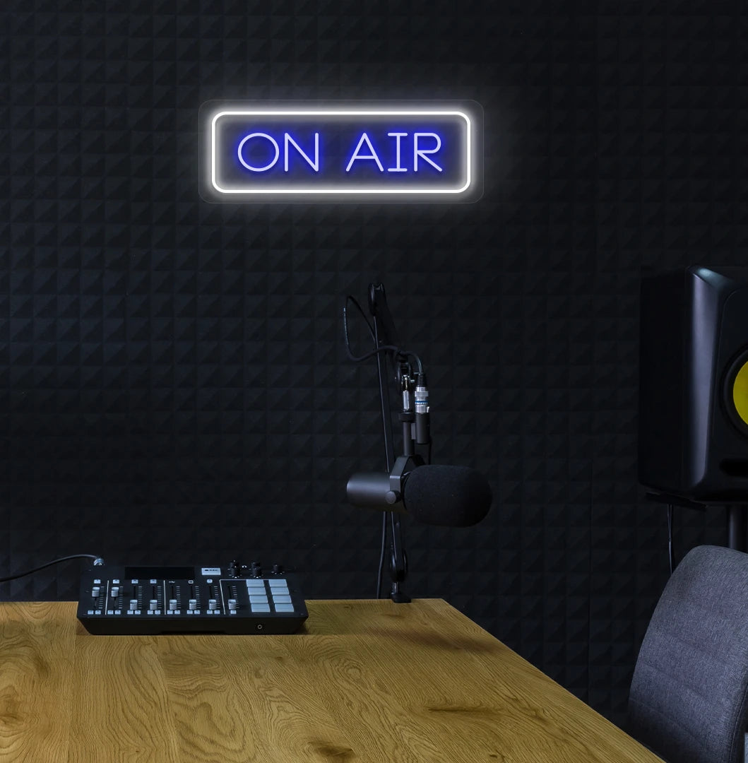 Stylish ON Air neon sign in blue mounted on studio wall.