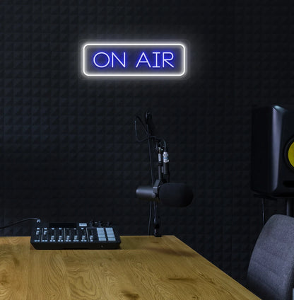 Stylish ON Air neon sign in blue mounted on studio wall.