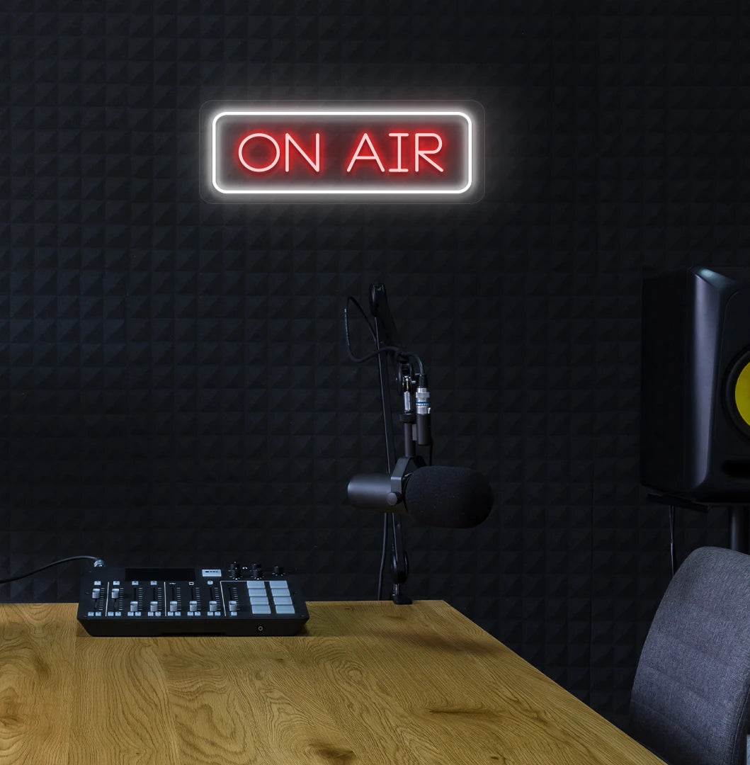 Stylish ON Air neon sign in red mounted on studio wall.