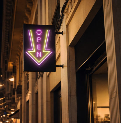 Image of an open arrow neon sign glowing on outdoor shop stand in pink color.