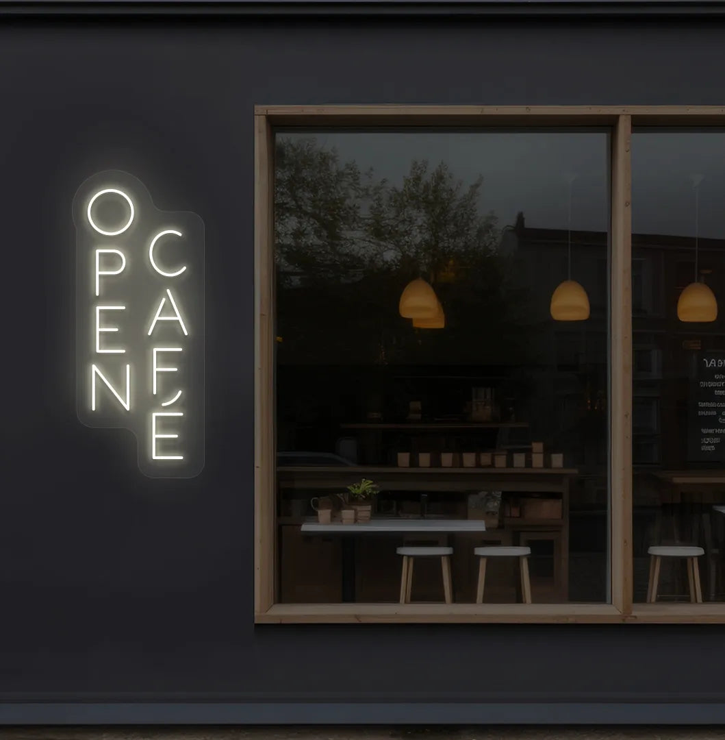 Trendy open cafe neon sign in warm white mounted on coffee shop wall.