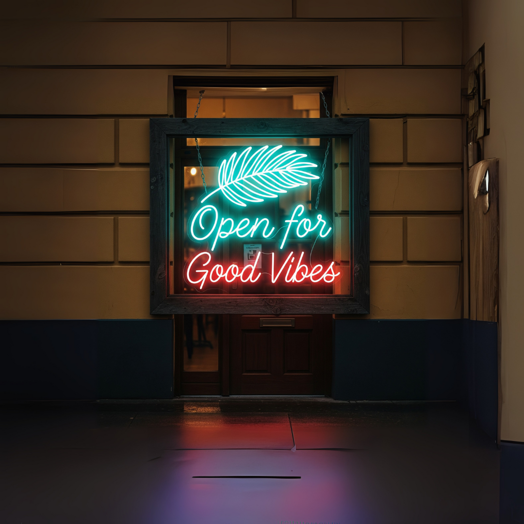 Image of an "open for good vibes" LED neon sign in purple and red colors on a shop window display with a leaf design.