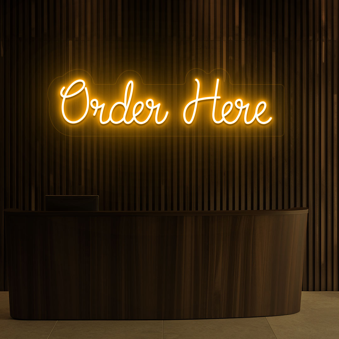 A stylish orange LED "order now" neon sign is glowing on the cafe wall above the counter.