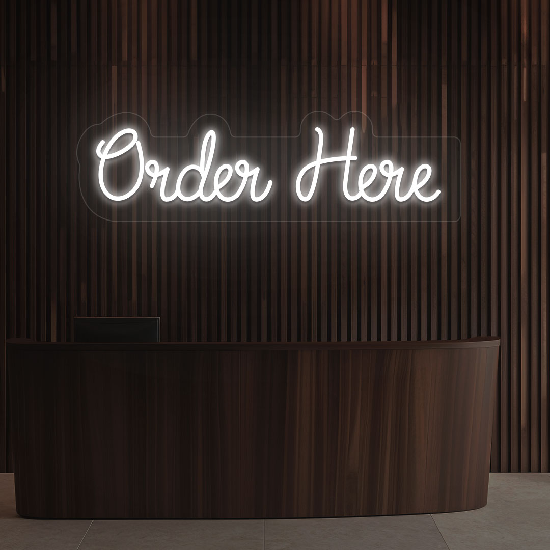 A stylish white LED "order now" neon sign is glowing on the cafe wall above the counter.
