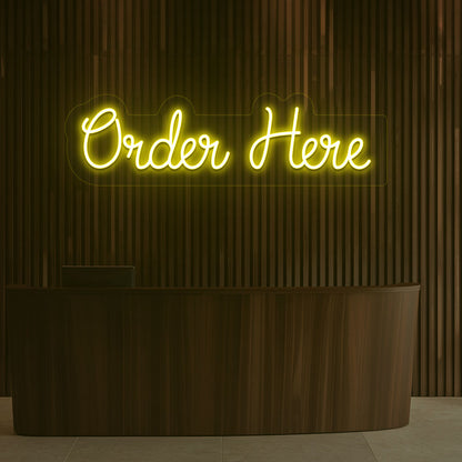 A bright yellow "order now" neon sign is hanging on the cafe's wooden wall. Perfect for cafés, restaurants, food counters, and retail service counters.