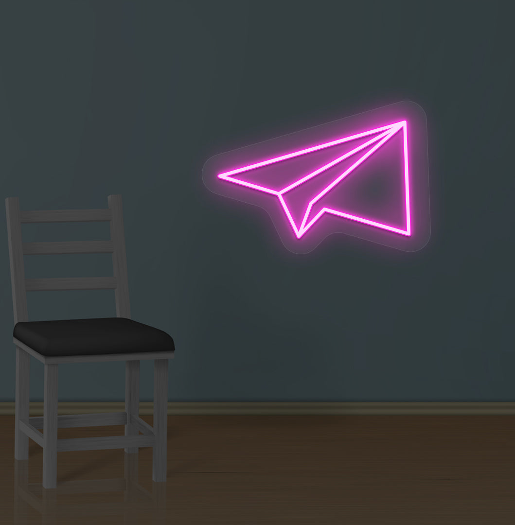 Image of a paper plane LED neon sign glowing on a wall in pink color.