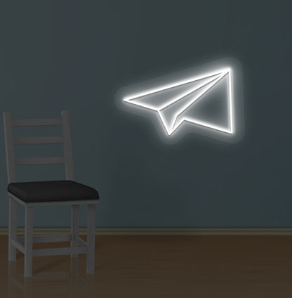 Image of a paper plane LED neon sign glowing on a wall in white color.