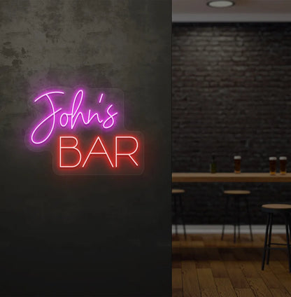 Personalized Bar Name neon sign mounted on decorative wall in pink color.